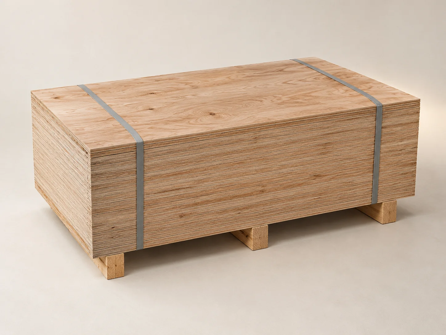 Strapped bundle of unsanded packing plywood on wooden bearers, sheet edges along the long side